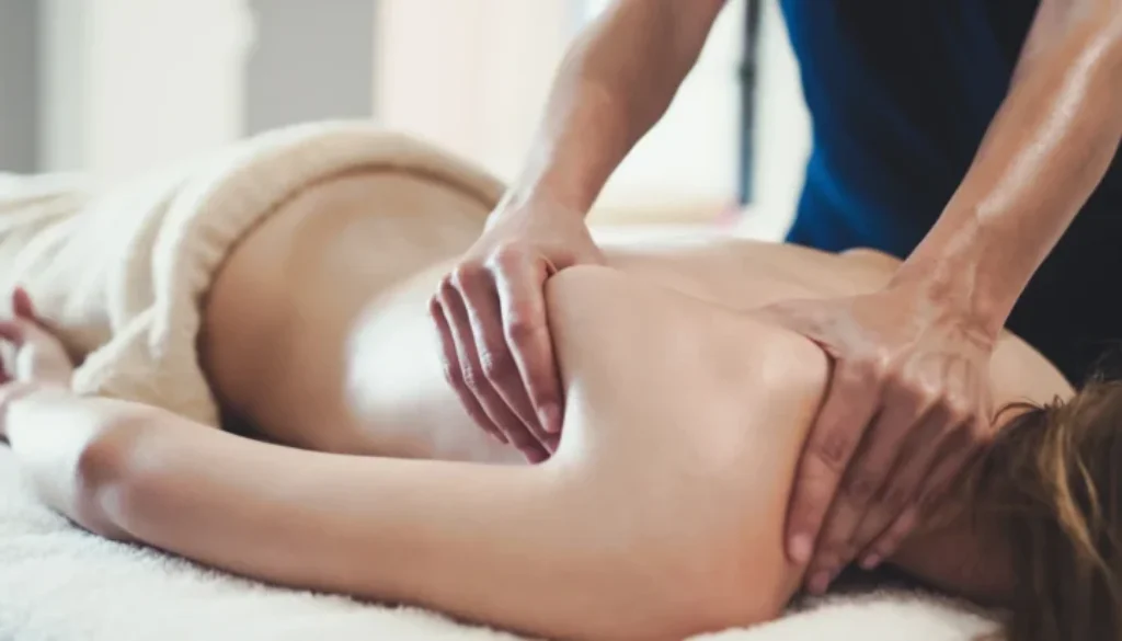 Massage being preformed on a woman's shoulder and back