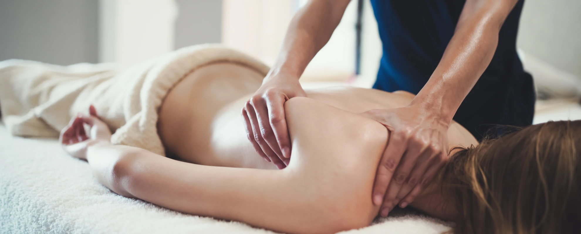 Massage being preformed on a woman's shoulder and back